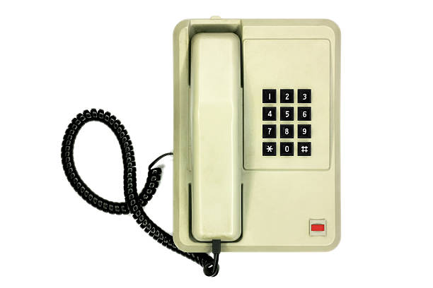 Old simple office desk phone isolated on white background