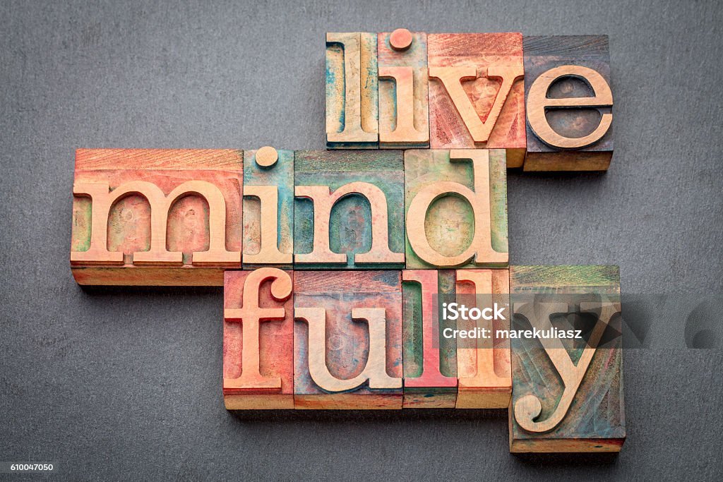 live mindfully in wood type live mindfully - word abstract in letterpress wood type against gray slate stone Mindfulness Stock Photo