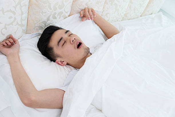 istock Young man asleep in bed snoring 610047522