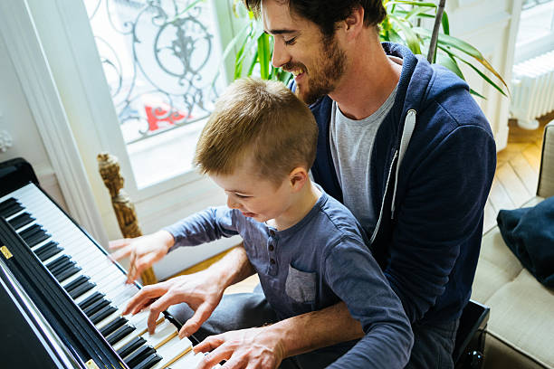 padre e hijo jugando juntos en casa, piano - pianist grand piano piano playing fotografías e imágenes de stock