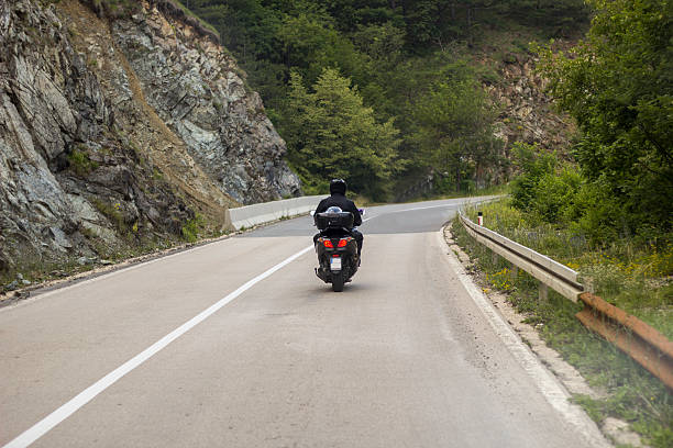 istock Biker riding scooter on an mountain road 610049556