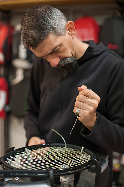 stringer da tennis che tiene il cappuccio e fa il racket stringing - racket tennis stringing restringing foto e immagini stock