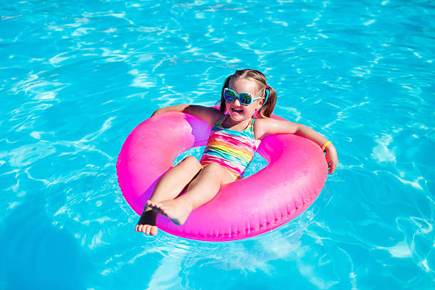 little girl with toy ring in swimming pool - swimming child swimwear little boys imagens e fotografias de stock