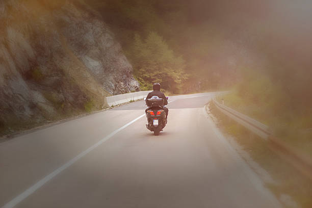 istock Biker on fokus riding motorcycle on asphalt road at sunset 610051186