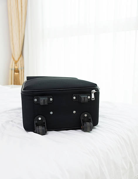 istock Single black suitcase on a hotel room bed 610051486