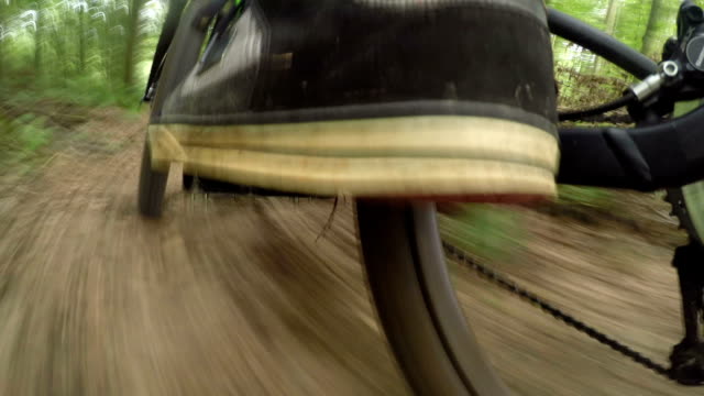CLOSE UP: Extreme downhill biker riding electric bicycle on forest trail