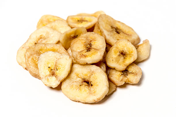 istock Pile of dried banana chips isolated on white background 610116710