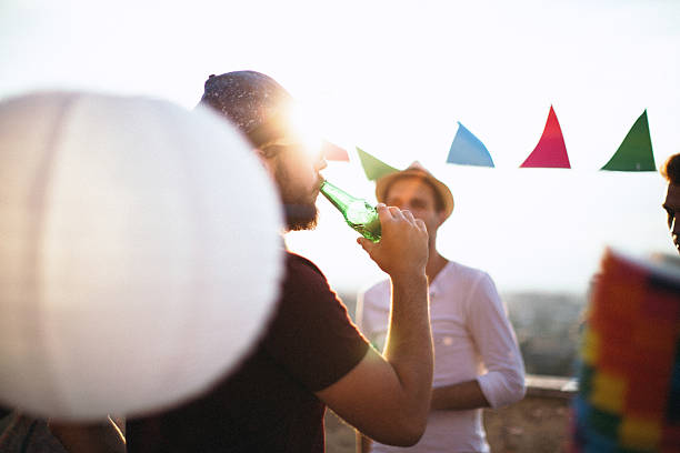 istock Man drinking beer on party with friends 610118222