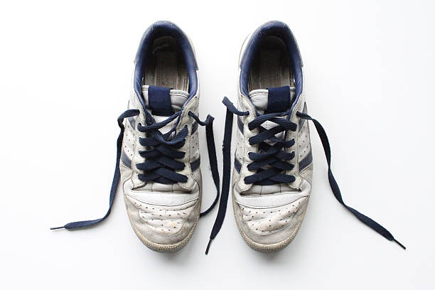 Pair of worn, white vintage sneakers shot from above Clean, isolated shot of a pair of old sports shoes, in heavily worn condition. exercise machine photos stock pictures, royalty-free photos & images