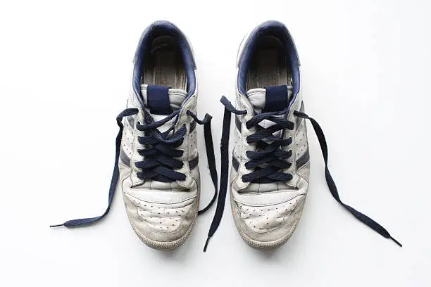 Photo of Pair of worn, white vintage sneakers shot from above