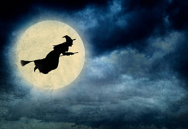 Witch Riding On Broom In Front Of Hazy Full Moon A Halloween witch and riding on a broom is silhouetted in front of a hazy full moon. broom photos stock pictures, royalty-free photos & images