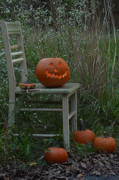 istock illuminated Halloween jackolantern outdoors on chair 610119542