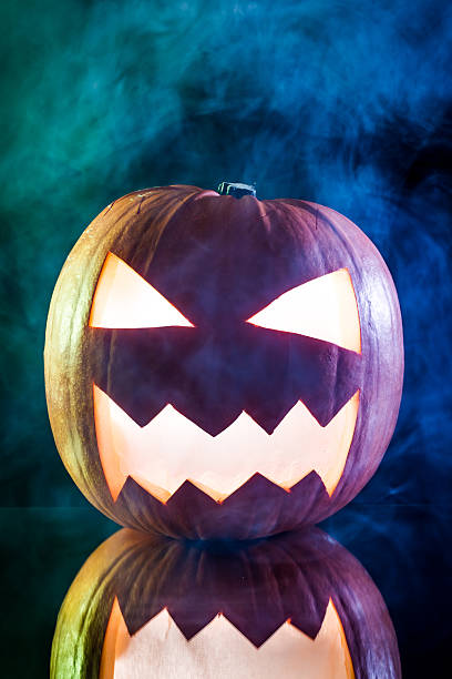 rauchen beängstigend halloween kürbis kopf auf schwarzem hintergrund - smoking orange ideas mystery stock-fotos und bilder