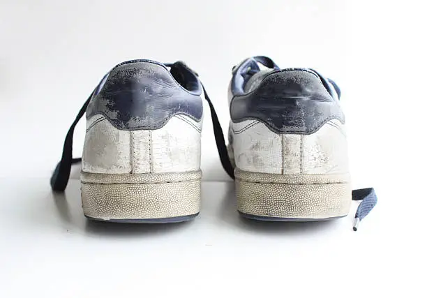 Photo of Low angle, heel of a pair of worn, white vintage sneakers