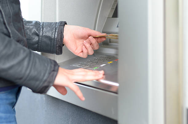 istock Young woman making a banking withdrawal 610122196