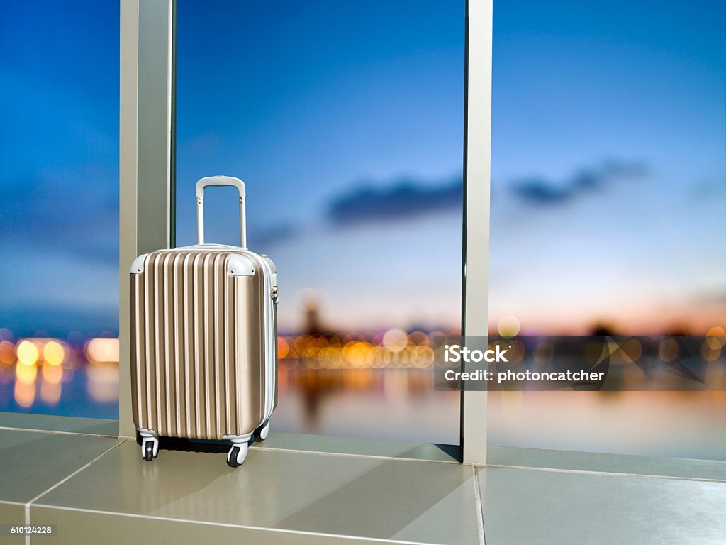 business travel concept business travel,suitcase at window in tower building against blur background Beginnings Stock Photo