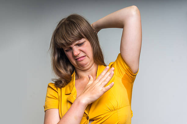 istock Woman with sweating under armpit in yellow dress 610128554