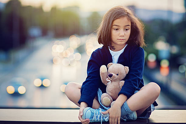 istock Little girl is standing sad on the bridge 610129624