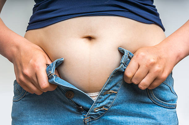 istock Overweight woman getting dressed wearing jeans 610129944