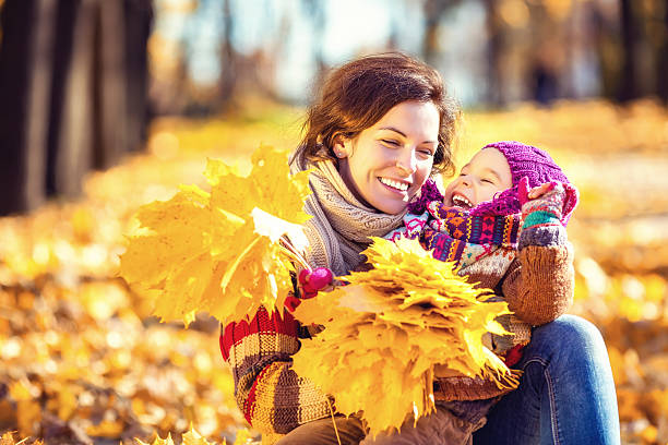 istock Mother and daughter playing in autumn park 610130010