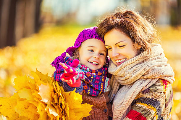 istock Mother and daughter playing in autumn park 610130072