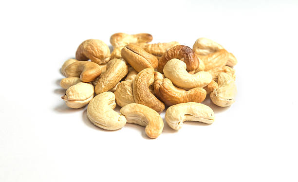 castanhas de caju destaque no fundo branco - healthy eating macro close up nut - fotografias e filmes do acervo