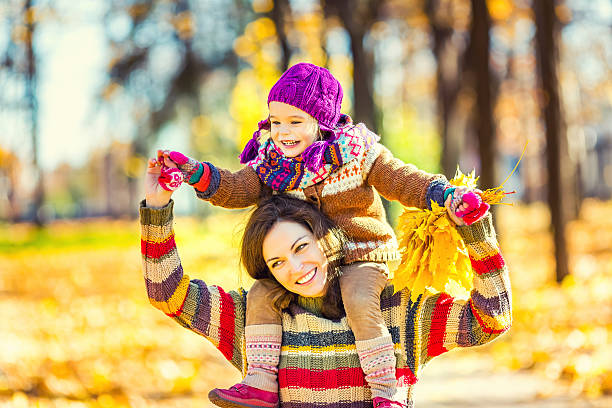 istock Mother and daughter playing in autumn park 610130292