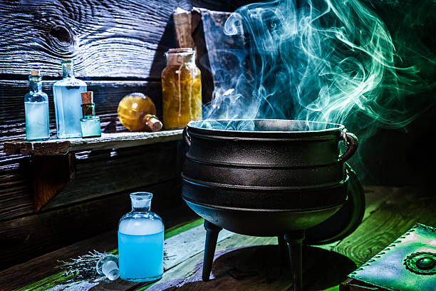 istock Vintage witcher cauldron with blue smoke and potions for Halloween 610130568