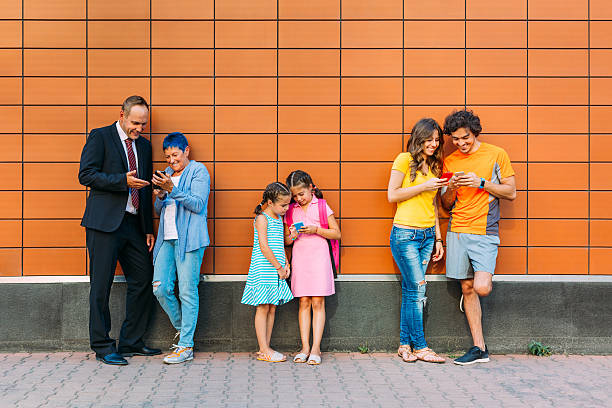 istock Mixed age range of people texting outdoors 610131654