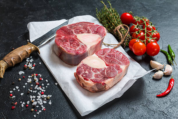 Raw veal shank slices meat Raw veal shank slices meat and ingredients for Osso Buco cooking on black background, top view ossobuco stock pictures, royalty-free photos & images