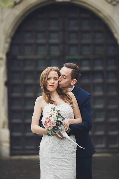 istock Happy wedding couple hugging and smiling each other on background 610135894