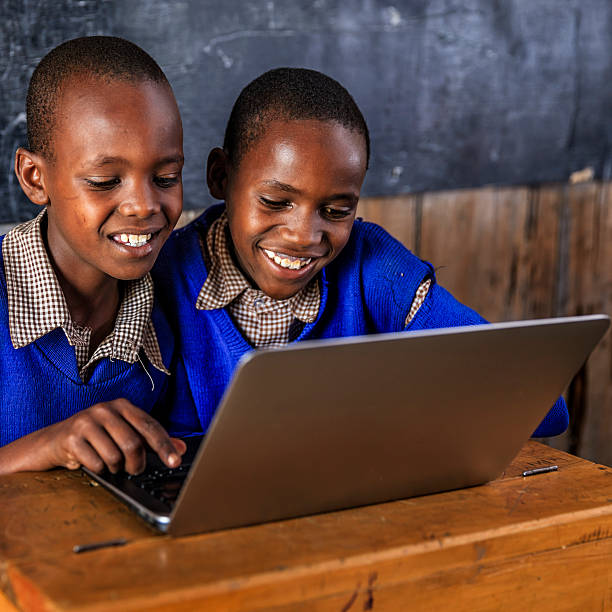 enfants africains utilisant un ordinateur portable dans une salle de classe, kenya - african descent africa african culture classroom photos et images de collection