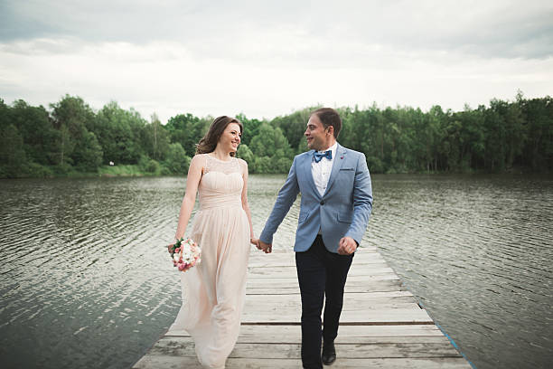 istock Wedding couple, bride, groom walking and posing on pier 610137978