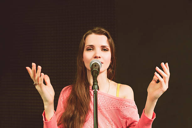 istock Young pretty female preacher speaking into mic 610138682