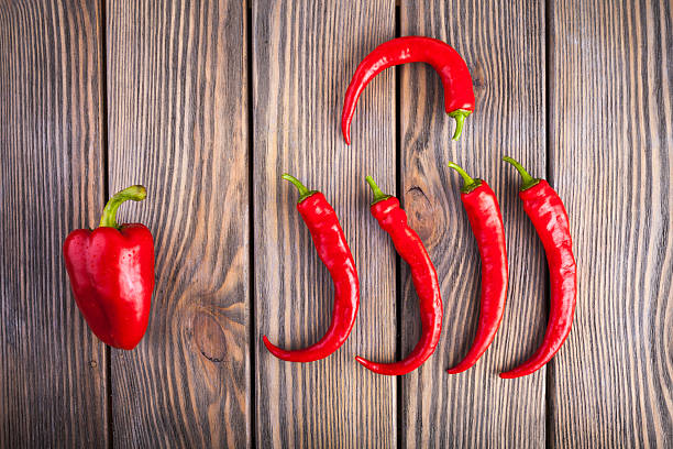 czerwone gorące chili i papryka na drewnianym tle - mexico chili pepper bell pepper pepper zdjęcia i obrazy z banku zdjęć