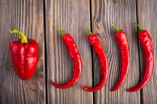 czerwone gorące chili i papryka na drewnianym tle - mexico chili pepper bell pepper pepper zdjęcia i obrazy z banku zdjęć