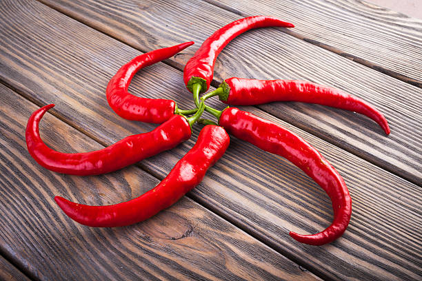 istock Red hot chili peppers on wood background 610139012