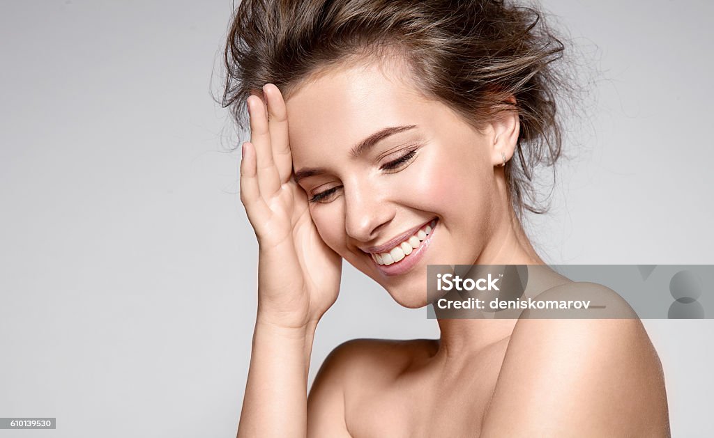 Beautiful smiling woman with clean skin and white teeth Beautiful smiling woman with natural make-up, clean skin and white teeth on grey background Skin Care Stock Photo