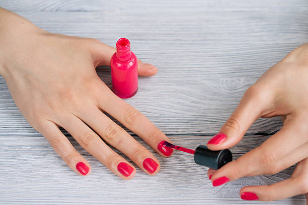 istock Female hands painted nails with red lacquer, close-up 610141614