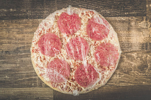 Delicious mouth watering raw frozen pizza on a kitchen table