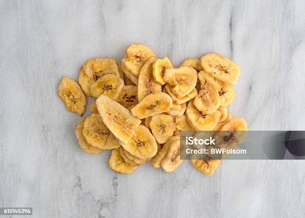 Dried Bananas On A Marble Cutting Board Stock Photo - Download Image Now - Banana Chip, Crunchy, Cutting Board