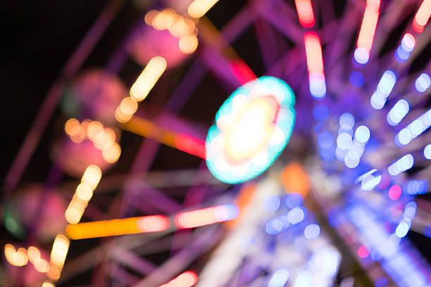 grande roue géante floue - ferris wheel flash photos et images de collection