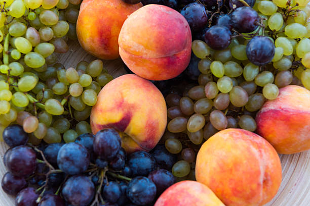 istock peaches and grapes in a plate on the table 610149424