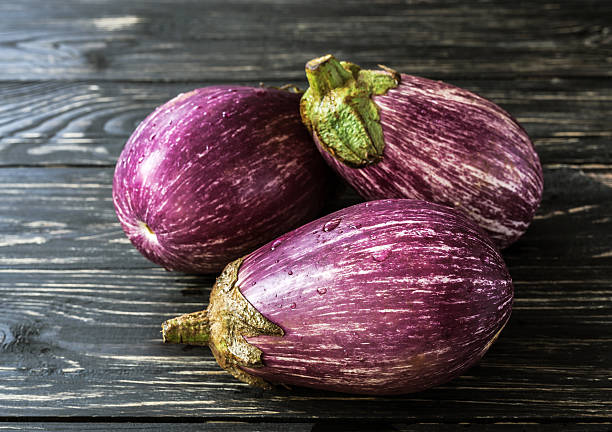 istock Organic eggplant on wooden background. Harvest concept. 610149614