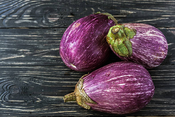 istock Organic eggplant on wooden background. Harvest concept. 610149696