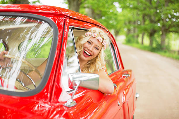 istock Happy woman driving a retro car 610150016