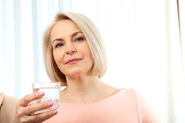 istock Middle aged woman drinking water in morning. 610150728