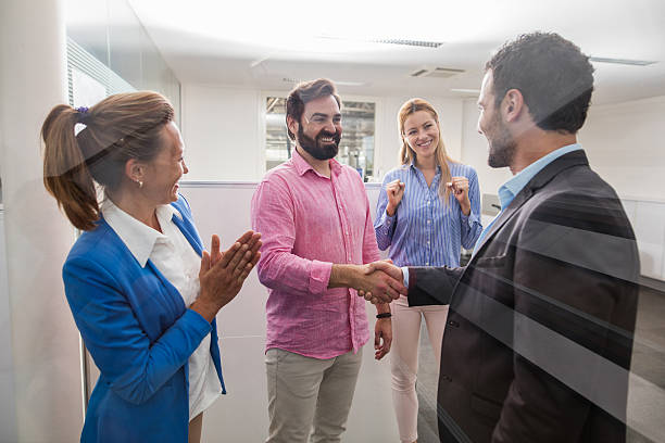istock Successful businessmen shaking hands in office building hallway. 610150824