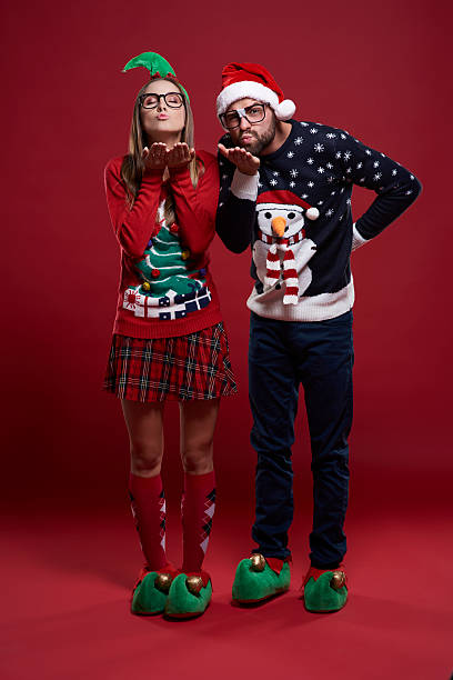 Couple of nerds sending sweet kisses Couple of nerds sending sweet kisses christmas nerd sweater cardigan stock pictures, royalty-free photos & images