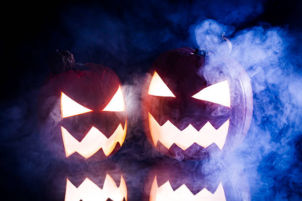 zwei rauchende kürbisse für halloween und blaulicht - smoking orange ideas mystery stock-fotos und bilder